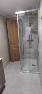 y baño con ducha y puerta de cristal. en Bruma, en Barreiros
