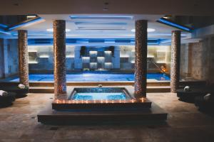 uma piscina num hotel com luzes no chão em Hotel Alexandar Lux em Podgorica