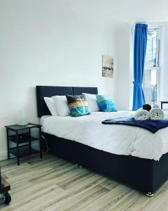 een slaapkamer met een groot bed en blauwe gordijnen bij Keepers Rest Scarborough North Bay in Scarborough
