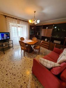 uma sala de estar com um sofá vermelho e uma mesa em Nonna Dorina Casa Vacanze em Pietrabbondante
