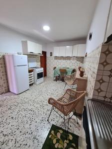- une cuisine avec des appareils blancs, une table et des chaises dans l'établissement Nonna Dorina Casa Vacanze, à Pietrabbondante