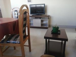 a living room with a table and a tv and a chair at Apartamentos MI FAMILIA in Sucre