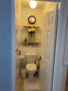 La salle de bains est pourvue de toilettes et d'une horloge murale. dans l'établissement One Double bedroom in a Shared apartment, à Londres