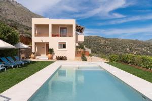 a villa with a swimming pool and a house at Triopetra Luxury Villas Panagia in Triopetra