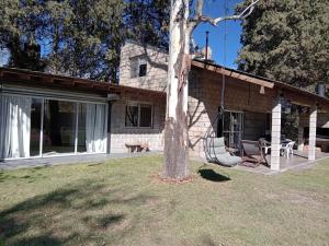 una casa con un árbol en el patio en Casa Quinta Roen Gral Rodriguez zona oeste en General Rodríguez