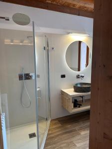 a bathroom with a sink and a shower with a mirror at Nogherazza - La Locanda in Belluno