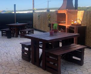 una mesa de madera y bancos en un patio en Casal dos Carpinteiros - Carpenters Couple, en Silveira