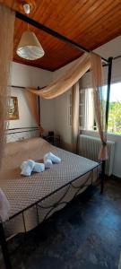 1 dormitorio con 1 cama con toallas en A flower house, en Mantoúkion