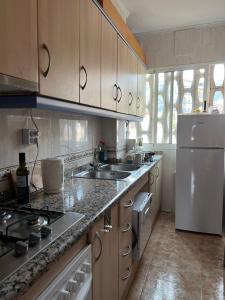 PL IFACH SOLYMAR في كاليبي: مطبخ مع مغسلة وثلاجة بيضاء