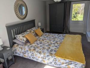 a bedroom with a bed with yellow sheets and a mirror at Applegrove, perfect 2 bed bungalow, Fortrose in Fortrose