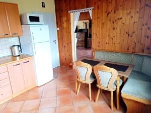 een keuken met een tafel en stoelen en een koelkast bij Vila Caba in Křemže