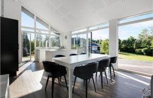 eine Küche und ein Esszimmer mit einem weißen Tisch und Stühlen in der Unterkunft 3 Bedroom Gorgeous Home In Ebeltoft in Ebeltoft