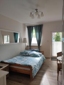 a bedroom with a bed with a blue comforter at Kamionka in Sopot