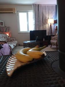 un montón de plátanos sentados en una bandeja en una sala de estar en Garden Village Home, en Ayvalık