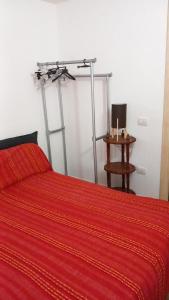 a red bed with a red blanket and a table at La dolce dimora in Olbia +32 photos