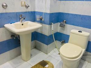 a bathroom with a toilet and a sink at Pool & Park Hotel in Lahore