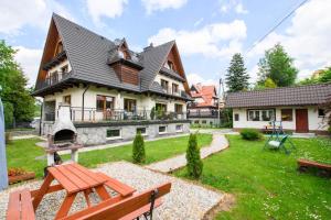 una casa con una mesa de picnic en el patio en Willa Mozaika, en Zakopane