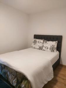 1 cama con sábanas blancas y almohadas en una habitación en Maison Nasko en Dinant