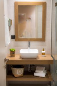 a bathroom with a sink and a mirror at Nissos Apartments in Myrina