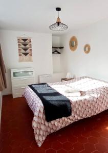 Un dormitorio con una cama con una manta blanca y negra. en La Douce Cathare, en Carcassonne