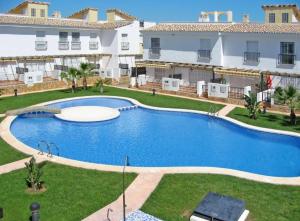 a large swimming pool in the yard of a building at Casa adosada con piscina y dos terrazas in Alcossebre
