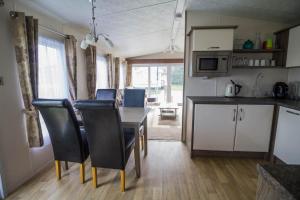 a kitchen and dining room with a table and chairs at Modern 6 Berth Caravan At Highfield Grange In Essex Ref 26609p in Clacton-on-Sea