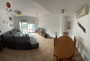 sala de estar con sofá y mesa en Casa adosada con piscina y dos terrazas en Alcossebre
