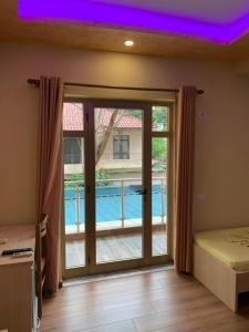 um quarto com uma porta de vidro deslizante que leva a uma piscina em Hotel Besa em Shëngjin