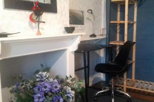 un dipinto di un camino con una sedia e fiori di Home Sweet Home a Monflanquin