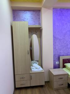 a bathroom with a vanity with a mirror and a bed at Hotel Besa in Shëngjin
