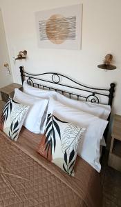 a bed with white and black pillows on it at Pension Hara in Patitiri