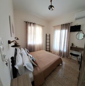 a bedroom with a bed and a table and window at Pension Hara in Patitiri