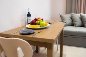 a wooden table with a plate of fruit on it at Nissos Apartments in Myrina