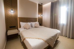 a bedroom with a large white bed and a window at Nissos Apartments in Myrina