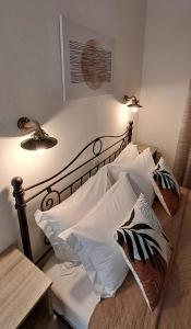 Una cama con sábanas blancas y almohadas. en Pension Hara, en Patitiri