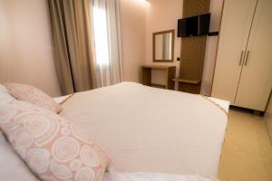 a bedroom with a large white bed with a mirror at Nissos Apartments in Myrina