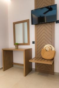 a room with a mirror and a tv on a wall at Nissos Apartments in Myrina