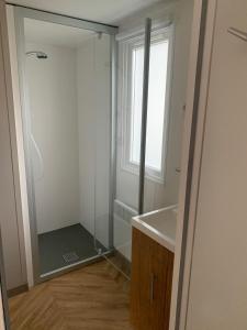 a bathroom with a shower and a sink and a mirror at Mobil Home Ronce Les Bains in Ronce-les-Bains