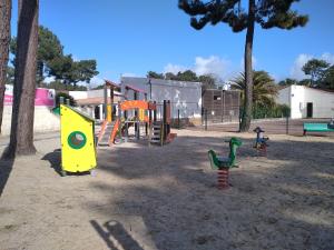 a playground with toys in the sand in a park at Mobil Home Ronce Les Bains in Ronce-les-Bains