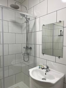 een witte badkamer met een wastafel en een douche bij Keepers Rest Scarborough North Bay in Scarborough