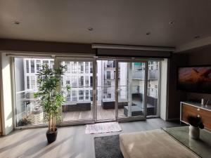 ein Wohnzimmer mit einem großen Fenster mit Stadtblick in der Unterkunft Penthouse in Bergen