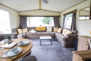 a living room with a couch and a table at Great 8 Berth Caravan For A Staycation In Clacton-on-sea Ref 26436e in Clacton-on-Sea