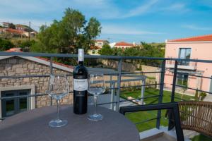 a bottle of wine sitting on a table with two glasses at Nissos Apartments in Myrina
