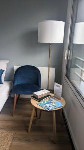 Habitación con mesa, silla y lámpara. en Appartements au Cœur de Maine, en Angers