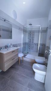uma casa de banho com um WC, um lavatório e um chuveiro em Helianthus em Assemini