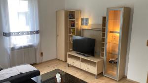 un salon avec une télévision sur un support dans l'établissement Ferienwohnung -Isola Madre, à Biebesheim