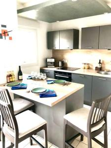 a kitchen with a table with two chairs and a counter at Confort plage piscine in Saint-Vincent-de-Tyrosse