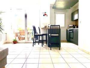 a kitchen with a table and chairs on a tiled floor at Confort plage piscine in Saint-Vincent-de-Tyrosse