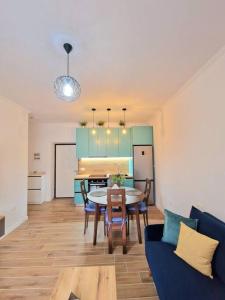 a living room with a table and a blue couch at Rafaela Sea Apartment in Sarandë