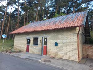 a small brick building with an orange roof at Varuna jachta in Nida +17 photos